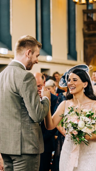 Bride and groom laugh at the alter