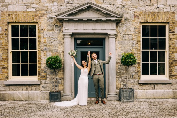 Bride and groom cheers celebrate at entrance to wedding venue