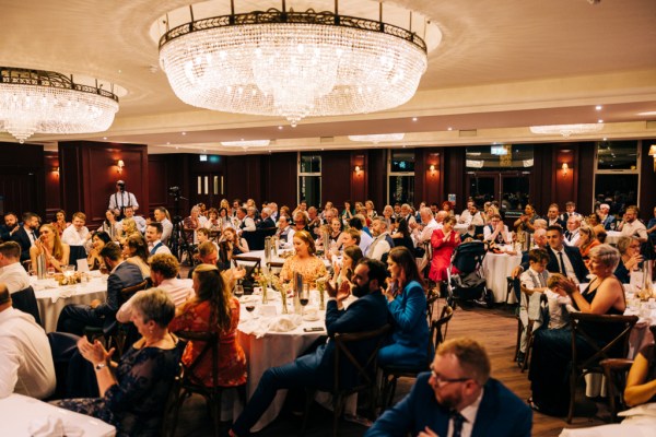 Father gives speech to guests bride and groom as they are seated