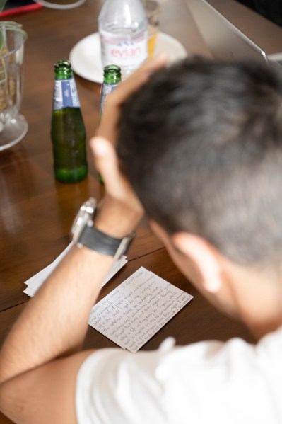 Groom reading letters hand on head watch detail