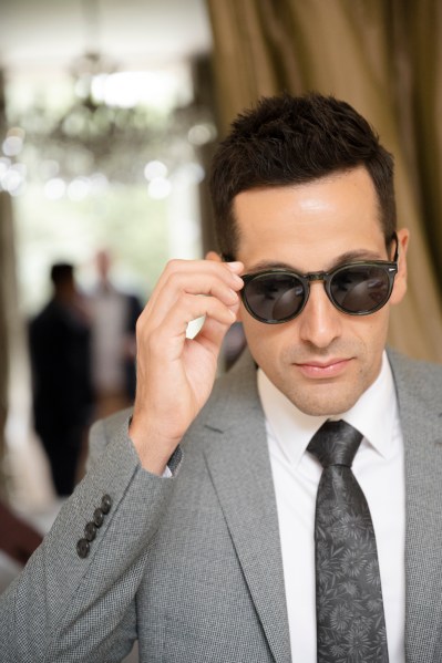 Groom wearing black sunglasses and black tie