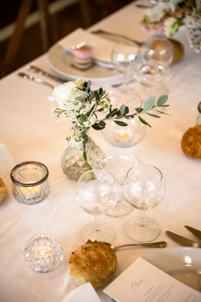 Flowers on the table dining room glasses candles lit roses cutlery