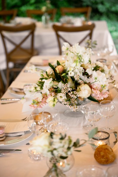 Flowers on the table dining room glasses candles lit roses cutlery