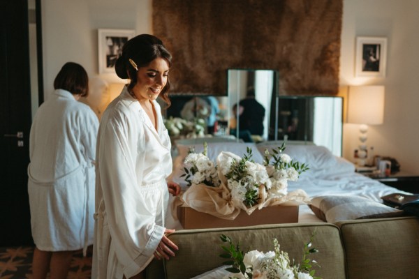 Bride looking at bouquet/flowers white roses