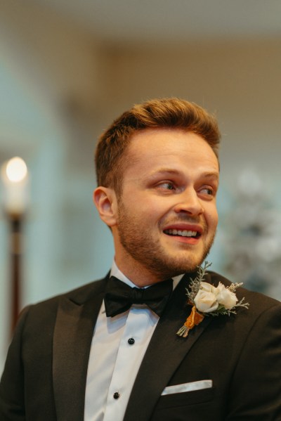 Groom awaits the bride in church smiling