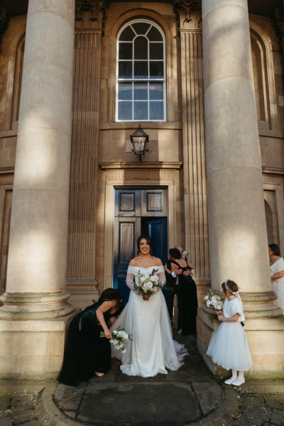 Little girl bridesmaids and bride stand outside the wedding venue