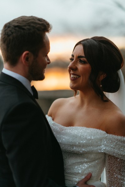 Dark evening shot of bride and groom looking at each other