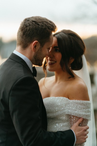 Bride and groom close to each other smile at each other