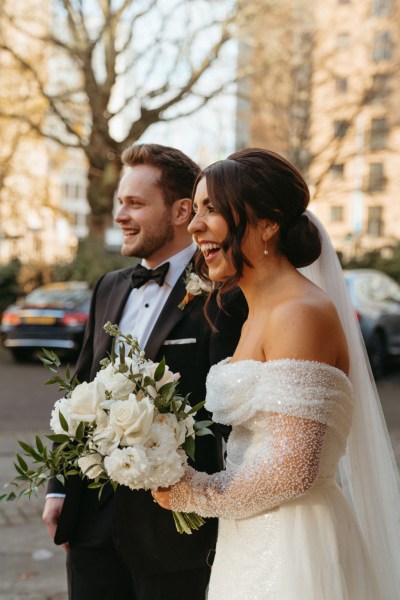 Bride and groom laughing she holds bouquet