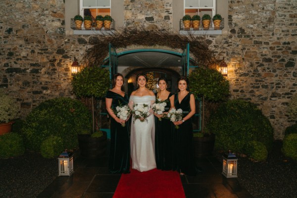 Bride and bridesmaids pose outside wedding venue