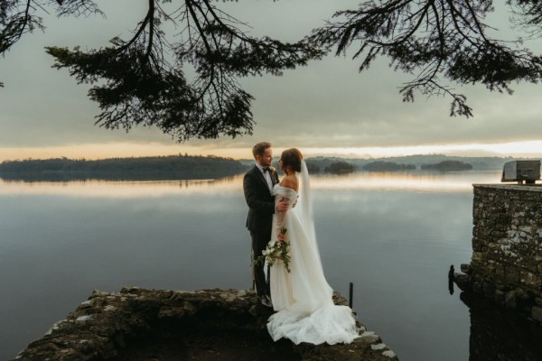 Bride and groom on the edge at lake view sea in background