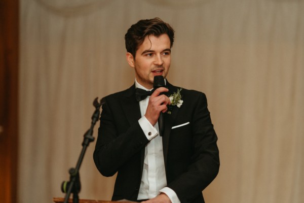 Groomsman friend gives speech speaks into microphone