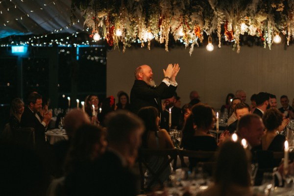 Groomsman claps in front of crowd