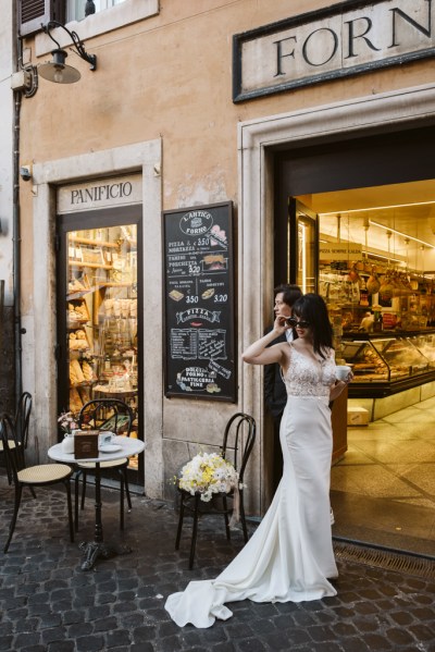 Bride and groom at entrance to cafe flowers on wooden seat