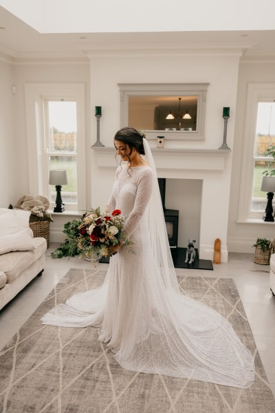 Bride ready for wedding holding bouquet of flowers in hand she looks down