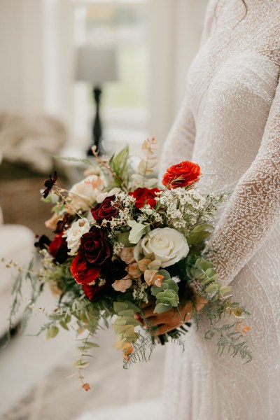 Bride ready for wedding holding bouquet of flowers in hand close up