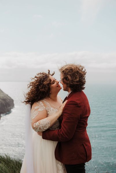 Bride and groom veil in the air Clare setting sea on the top of a cliff Irish landscape