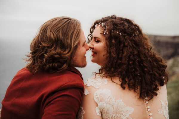 Bride and groom go in for a kiss landscape cliff setting