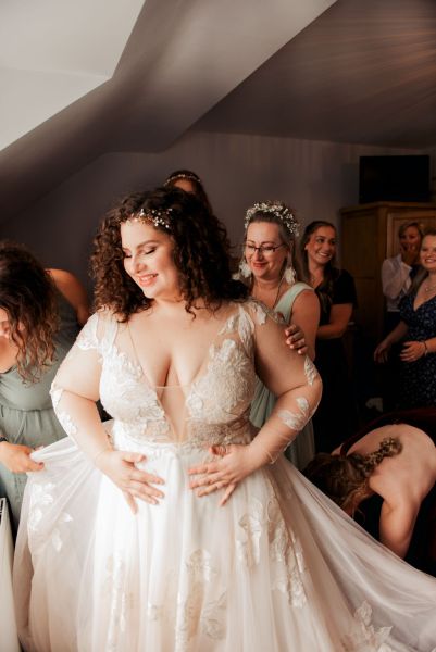 Bridesmaids and bride get ready together laughing smiling