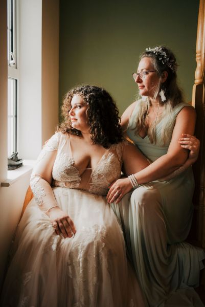 Emotional moment between mother and daughter smiling they look out the window