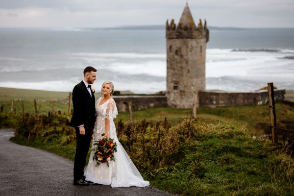 Castle setting bride and groom near farm park setting standing on the road