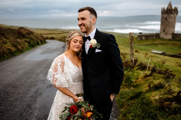 Castle setting bride and groom near farm park setting standing on the road smiling head on shoulders