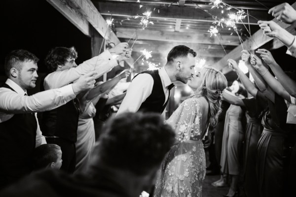 Black and white image of bride and groom guests have sparklers