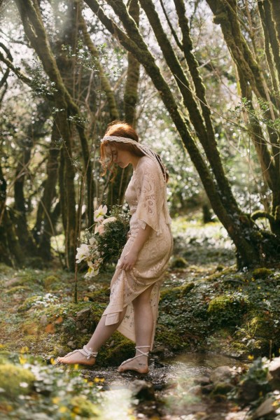 Model bride wearing headband walking around in forest