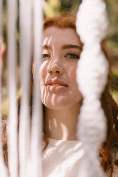 Model bride through string decor exterior forest setting smile