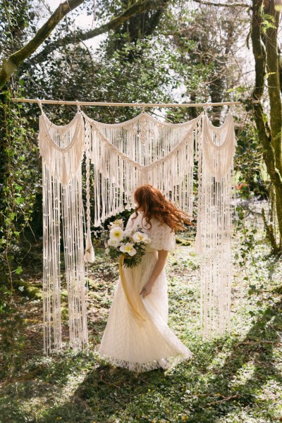 Ruby Rose exterior garden strings behind her she's holding bouquet white flowers sunflowers forest grass