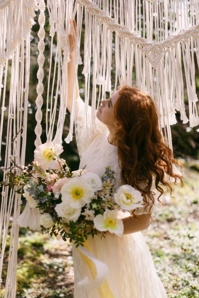 Ruby Rose exterior garden strings behind her she's holding bouquet white flowers sunflowers