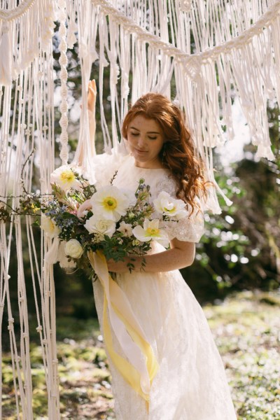 Ruby Rose exterior garden strings behind her she's holding bouquet white flowers sunflowers