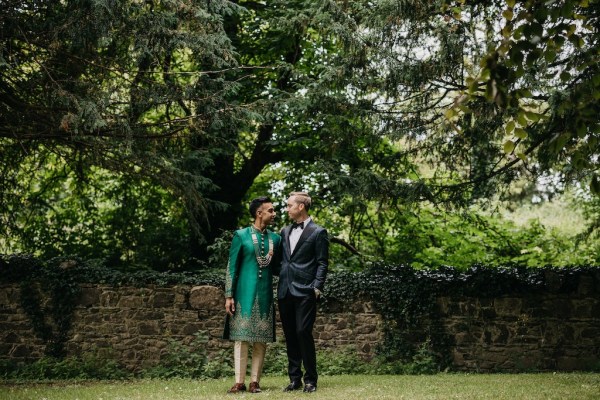 Grooms in garden tree in background and wall