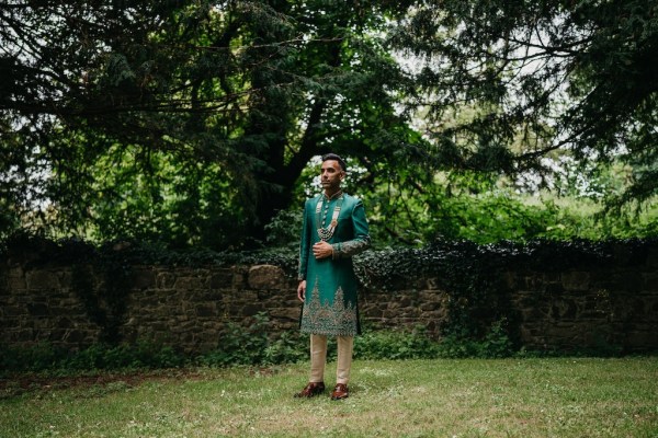 Grooms in garden tree in background and wall