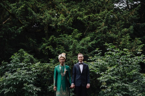 Grooms standing in garden surrounded by trees