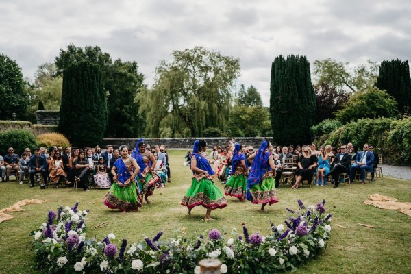 Dancers dancing before ceremony begins castle in background flowers and guests seated