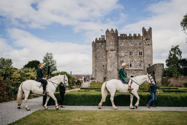 Groom on white horse makes entrance with groom behind him