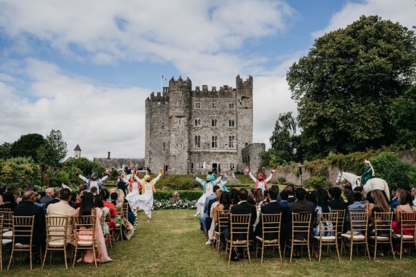 Dancers dancing on grass in front of guests seated