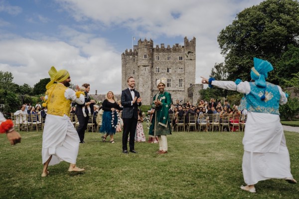 Grooms surrounded by guests and dancers