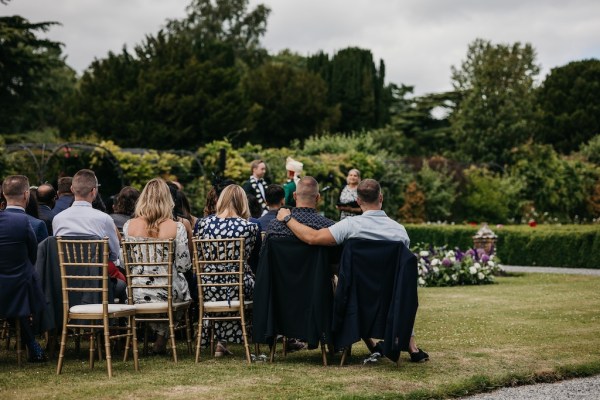 Guests seated during ceremony chairs on grass