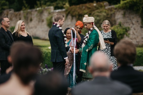 Guests and two grooms at alter with celebrant