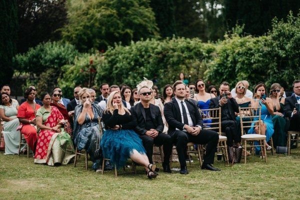 Guests during ceremony on grass seated