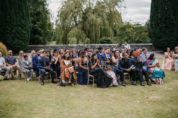 Guests during ceremony on grass seated