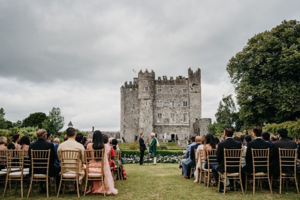 Castle view guests and grooms at alter