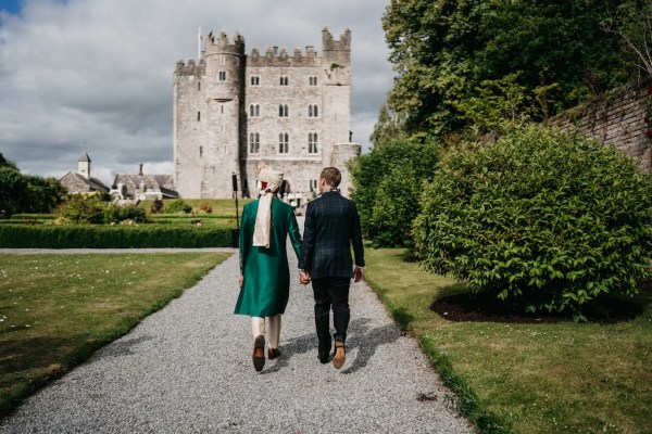 Grooms walk towards wedding venue castle