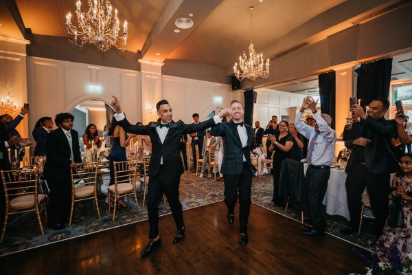 Groom and groom enter the room with guests