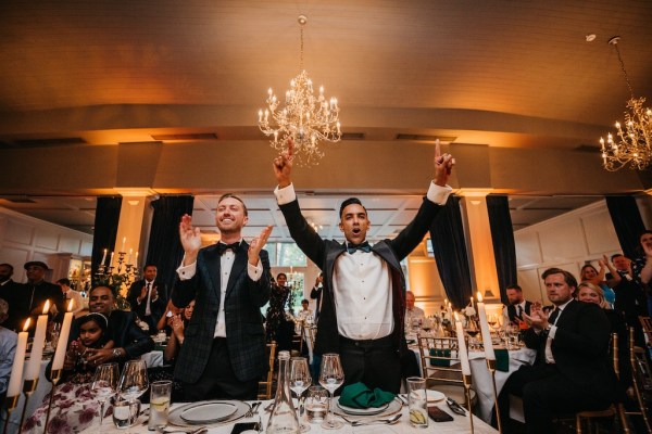 Grooms standing clapping during speech