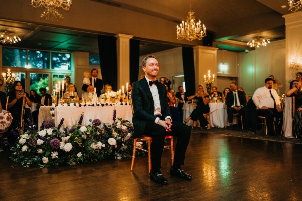 Groom sits on chair