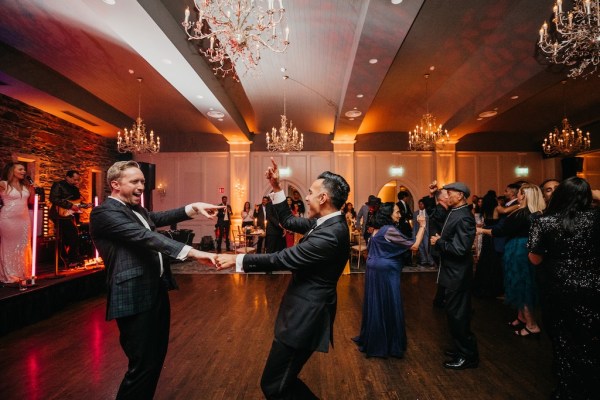 Grooms dance on dancefloor together