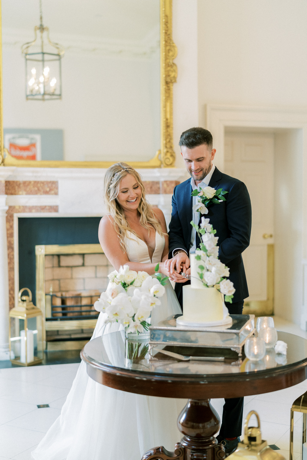 Bride and groom cutting the white wedding cake